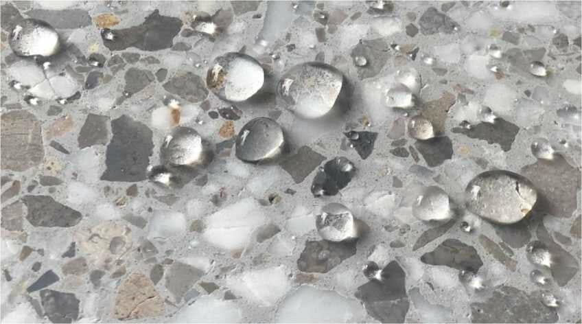 Drops of water beading on surface of concrete