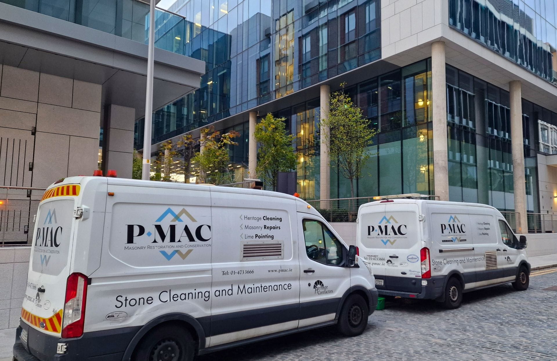 2 vans Two Pmac vans outside office building